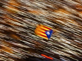 An independence flag is waved as demonstrators take part at a protest calling for the release of Catalan jailed politicians, in Barcelona, Spain, on Saturday, Nov 11, 2017. Eight members of the now-defunct Catalan government remain jailed in a related rebellion case. Former regional president Carles Puigdemont and four other ex-cabinet members fled to Belgium where they are fighting extradition. (AP Photo/Emilio Morenatti)