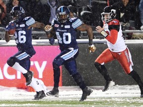 Toronto Argonauts defensive back Cassius Vaughn (left) races away from Calgary Stampeders quarterback Bo Levi Mitchell for a fumble recovery touchdown in the Grey Cup on Nov. 26, 2017.