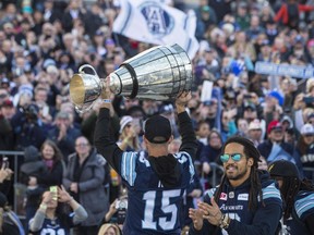 Toronto Argonauts quarterback Ricky Ray holds the Grey Cup at a rally at City Hall in Toronto on Nov. 28.