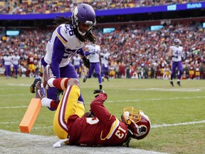 Washington Redskins wide receiver Maurice Harris (13) collides with Minnesota Vikings cornerback Trae Waynes (26) as he rolls into the end zone for a touchdown during the first half of an NFL football game in Landover, Md., Sunday, Nov. 12, 2017. (AP Photo/Alex Brandon)