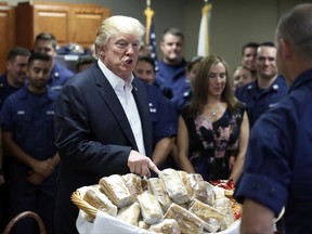 President Donald Trump prepares to hand out sandwiches to members of the U.S. Coast Guard at the Lake Worth Inlet Station, on Thanksgiving, Thursday, Nov. 23, 2017, in Riviera Beach, Fla. (AP Photo/Alex Brandon)