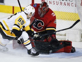 Goaltender Mike Smith of the Calgary Flames stones Jake Guentzel of the Pittsburgh Penguins from close in during NHL action Thursday night in Calgary. Smith was brilliant with 43 saves as the Flames prevailed 2-1 in overtime.