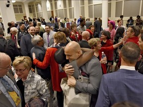 In this Tuesday Feb. 14, 2017 photo, Duval Schools Superintendent Nikolai Vitti, center, is hugged after the Jacksonville City Council voted 12-6 to support the Human Rights Ordinance (HRO) in Jacksonville, Fla. At left are Rabbi Rick Shapiro, the Interim Senior Rabbi at Congregation Ahavath Chesed, and Nancy Broner, Executive Director of OneJax. At the U.S. Capitol, and in most statehouses nationwide, supporters of LGBT rights are unable to make major gains these days. Instead, they're notching victories in scores of cities and towns that have acted on their own in Republican-governed states. (Bob Mack/Florida Times-Union via AP)
