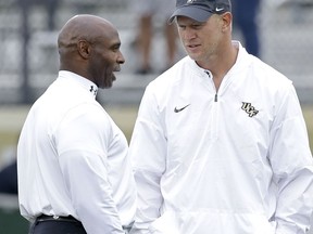 South Florida head coach Charlie Strong, left, greets Central Florida head coach Scott Frost before an NCAA college football game Friday, Nov. 24, 2017, in Orlando, Fla. (AP Photo/John Raoux)