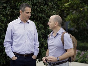 Thad Levine, left, general manager for the Minnesota Twins and New York Yankees general manager Brian Cashman, right, talk at the annual MLB baseball general managers' meetings, Tuesday, Nov. 14, 2017, in Orlando, Fla. (AP Photo/John Raoux)