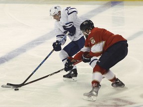 Toronto Maple Leafs' Mitchell Marner, left, and Florida Panthers' Aaron Ekblad, right, battle for the puck during the first period of an NHL hockey game, Wednesday, Nov. 22, 2017, in Sunrise, Fla. (AP Photo/Luis M. Alvarez)