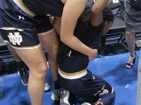 Notre Dame's Lili Thompson, right, is held by a teammate after their NCAA college basketball game against South Carolina at the final game of the Gulf Coast Showcase NCAA college basketball championship, Sunday, Nov. 26, 2017, in Estero, Fla. Notre Dame won 92-85. (AP Photo/Luis M. Alvarez)