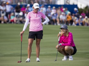 LPGA Tour pros Stacy Lewis, left, and Michelle Wie share a laugh while waiting to putt on the eighteenth green during the third round of the CME Group Tour Championship golf tournament, Saturday, Nov. 18, 2017 in Naples, Fla. Wie finished the day with a score of ten-under par while Lewis finished with a score of nine-under. (Luke Franke/Naples Daily News via AP)