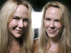 FILE- In this Oct. 12, 2011, file photo, Anastasia, left, and Alexandria Duval, known as Alison and Ann Dadow before they changed their names, stand in the window of their yoga studio in West Palm Beach, Fla. The attorney defending a woman accused of deliberately driving off a Maui, Hawaii cliff and killing her identical twin says prosecutors misled a grand jury that indicted her. A defense motion seeks to dismiss the indictment charging Alexandria Duval with murder. The motion says a Maui detective gave incorrect testimony about what an eyewitness saw. (Thomas Cordy/Palm Beach Post via AP, File)