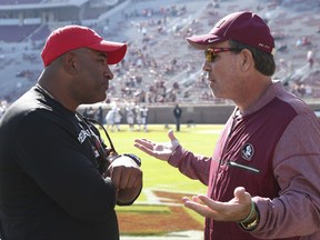 Florida State's head coach Jimbo Fisher, right, meets Delaware State's head coach Kenny Carter at mid field before the start of an NCAA college football game, Saturday, Nov. 18, 2017, in Tallahassee Fla. (AP Photo/Steve Cannon)