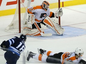Bryan Little of the Winnipeg Jets lets go with a shot that is knocked down by Philadelphia Flyers' goaltender Brian Elliott during NHL action Thursday night in Winnipeg. The Jets spotted the Flyers a 2-0 lead before roaring back to win 3-2 in a shootout.