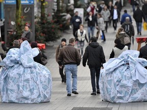 FILE - In this Nov. 24, 2017 file photo road blocks wrapped like Chistmas presents secure the way to the Christmas market in Bochum, Germany. German Christmas markets are still considered as potential targets for terror attacks. (AP Photo/Martin Meissner, file)