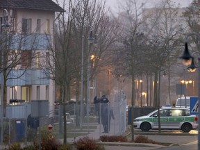 A police car stands outside an asylum seeker center in Bamberg, southern Germany, Wednesday, Nov. 15, 2017 after one person was killed and several injured in a fire inside the center. (Daniel Karmann/dpa via AP)