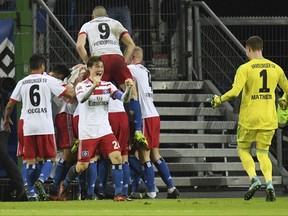 Hamburg's Gideon Jung (covered) celebrates with his teammates after scoring his side's third goal during the German Bundesliga soccer match between Hamburger SV and 1899 Hoffenheim in the Volksparkstadion in Hamburg, Germany, Sunday, Nov. 26, 2017. (Daniel Reinhardt/dpa via AP)