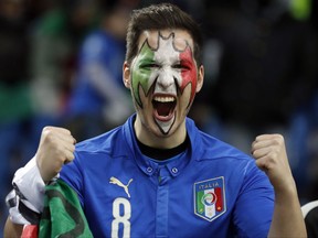 A Italy fan, his face painted in the colors of the national flag, cheers prior to the World Cup qualifying play-off second leg soccer match between Italy and Sweden, at the Milan San Siro stadium, Italy, Monday, Nov. 13, 2017. (AP Photo/Antonio Calanni)