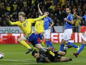 Sweden's Emil Forsberg, left, jumps past Italy goalkeeper Gianluigi Buffon during the World Cup qualifying play-off first leg soccer match between Sweden and Italy, at the Friends Arena in Stockholm, Friday, Nov. 10, 2017. (AP Photo/Frank Augstein)