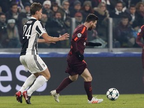 Barcelona's Lionel Messi is challenged by Juventus' Daniele Rugani, left, during the Champions League group D soccer match between Juventus and Barcelona, at the Allianz Stadium in Turin, Italy, Wednesday, Nov. 22, 2017. (AP Photo/Antonio Calanni)