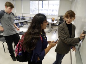 In this photo taken Oct. 11, 2017, Ellen Tara James-Penney, right, a lecturer at San Jose State University, talks with a student at the end of her English class on the university's campus in San Jose, Calif. The booming economy along the West Coast has led to an historic shortage of affordable housing and has upended the stereotypical view of people out on the streets. Reporting by The Associated Press finds that many of them are employed, working as retail clerks, plumbers, janitors _ even teachers. They go to work, sleep where they can and buy gym memberships for a place to shower. (AP Photo/Marcio Jose Sanchez)