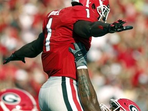 Georgia tailback Sony Michel (1) celebrates with Georgia offensive guard Isaiah Wynn (77) after scoring a touchdown in the first half of an NCAA college football game against South Carolina in Athens, Ga., Saturday, Nov. 4, 2017. (Joshua L. Jones/Athens Banner-Herald via AP)