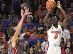 Florida guard Mike Okauru (0) shoots over Gardner-Webb guard Liam O'Reilly during the second half of an NCAA college basketball game in Gainesville, Fla., Monday, Nov. 13, 2017. Florida won 116-74. (AP Photo/Ron Irby)