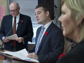 Nova Scotia Health Minister Randy Delorey is flanked by Dr. Robert Strang, left, chief medical officer, and Cindy MacIsaac, director of Direction 180 methadone clinic, at a news conference in Halifax on Wednesday, Nov. 8, 2017. The provincial government has added funds for treatment of opioid addictions as they face an ongoing crisis. THE CANADIAN PRESS/Andrew Vaughan
