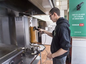 Mike MacInnis-Carr slices donair meat from the rotating spit at the King Of Donair restaurant in Halifax on Tuesday, Nov. 14, 2017. Nova Scotia Webcams features over 70 streams across the province and recently added the vertical rotisserie. A donair is a hot sandwich made with spiced meat on a pita, a white sauce, tomatoes and onions. THE CANADIAN PRESS/Andrew Vaughan