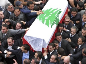 FILE - In this Feb. 16, 2005 file photo, the coffin carrying former Lebanese Prime Minister Rafik Hariri arrives for his funeral, in Beirut, Lebanon. Lebanon's Prime Hariri Saad Hariri who resigned from Saudi Arabia nearly two weeks ago has been caught in the crossfire between the region's two feuding powers -- Sunni Saudi Arabia and Shiite Iran. The 47-year-old who for years had tried to play a balancing act in Lebanon, with its delicate, sectarian-based political system, resigned in the most bizarre manner, throwing the country's and his own political future into the unknown. (AP Photo/Dalati Nohra, File)