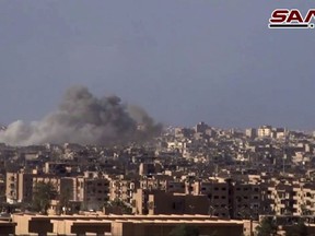 This frame grab from a video released on Nov. 2, 2017 by the Syrian official news agency SANA shows smoke and debris rising after Syrian government shelling of the Deir el-Zour city during a battle against Islamic State militants, Syria. The Syrian army announced on Friday, Nov. 3 it liberated the long-contested eastern city of Deir el-Zour from the Islamic State group. (SANA via AP)