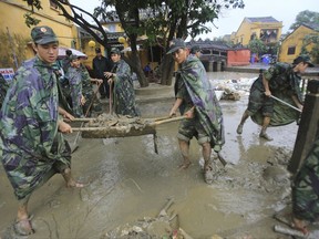 Soldiers clean up after flooding from a typhoon in Hoi An, Vietnam, Wednesday, Nov. 8, 2017. Typhoon Damrey caused extensive damage ahead of this week's Asia Pacific Economic Cooperation summit that will be attended by leaders from around the world, although those meetings that start Wednesday in the central city of Danang will not be affected. (AP Photo/Hau Dinh)