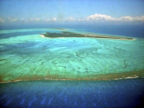 FILE--This June 2007, file aerial photo shows Midway Atoll, one of the farthest in the string of the Northwestern Hawaiian Islands with long stretches of pristine atolls and coral reefs. Nearly half of the Hawaii's coral reefs were bleached during heat waves in 2014 and 2015 and fisheries close to shore are declining, a group of scientists told state lawmakers. (Burl Burlingame, Honolulu Star-Bulletin via AP, file)