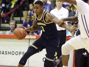 Michigan guard Charles Matthews (1) dribbles past LSU guard Brandon Rachal (2) during the first half of an NCAA college basketball game, Monday, Nov. 20, 2017, in Lahaina, Hawaii. (AP Photo/Marco Garcia)