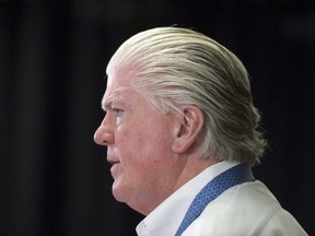 In this April 14, 2014 file photo, Calgary Flames president of hockey operations Brian Burke speaks to reporters.