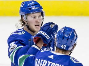 Brock Boeser, top, and Sven Baertschi, of the Canucks celebrate Boeser's second goal against the Pittsburgh Penguins during the second period of their game in Vancouver on Saturday night.