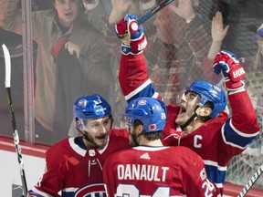 Montreal Canadiens' Max Pacioretty (67) celebrates with teammates Victor Mete (53) and Phillip Danault after scoring during overtime period against the Buffalo Sabres, in Montreal on Saturday.