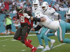 Tampa Bay Buccaneers middle linebacker Kwon Alexander (58) intercepts a pass as Miami Dolphins offensive guard Ted Larsen (62) grabs him by the helmet, during the first half of an NFL football game, Sunday, Nov. 19, 2017, in Miami Gardens, Fla. (AP Photo/Lynne Sladky)