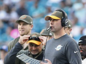 Miami Dolphins head coach Adam Gase watches his team during the second half of an NFL football game against the Tampa Bay Buccaneers, Sunday, Nov. 19, 2017, in Miami Gardens, Fla. Injured quarterback Ryan Tannehill is at left. (AP Photo/Wilfredo Lee)