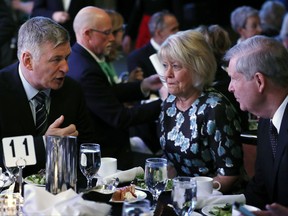 Actor Alec Baldwin, left, speaks with former U.S. Secretary of Agriculture Tom Vilsack, right, and his wife Christie during the Iowa Democratic Party's Fall Gala, Monday, Nov. 27, 2017, in Des Moines, Iowa. (AP Photo/Charlie Neibergall)