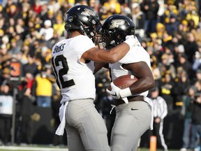 Purdue running back D.J. Knox, right, celebrates with teammate Jared Sparks after catching a 5-yard touchdown pass during the first half of an NCAA college football game against Iowa, Saturday, Nov. 18, 2017, in Iowa City, Iowa. (AP Photo/Charlie Neibergall)