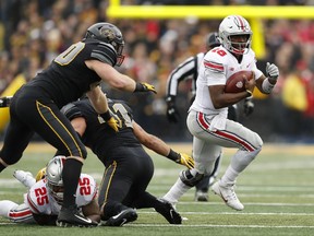 Ohio State quarterback J.T. Barrett (16) runs from Iowa defensive end Parker Hesse, left, during the first half of an NCAA college football game, Saturday, Nov. 4, 2017, in Iowa City, Iowa. (AP Photo/Charlie Neibergall)