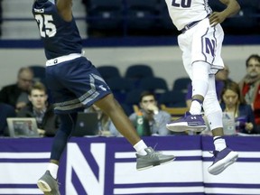 Northwestern 's Scottie Lindsey (20) blocks the shot of St. Peter's 's Cameron Jones during the first half of an NCAA college basketball game Monday, Nov. 13, 2017, in Rosemont, Ill. (AP Photo/Charles Rex Arbogast)