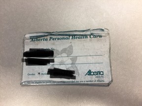 An Alberta Personal Health Card in its natural state: Frayed, battered and suffering from an ad hoc lamination attempt.