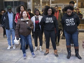 About two dozen people stand in front of the City-County Building in Indianapolis, Tuesday, Oct. 31, 2017, after the announcement that no charges would be filed against Indianapolis Metropolitan Police Department  officers Michal P. Dinnsen and Carlton J. Howard who fired their weapons at Aaron Bailey, resulting in his death on a traffic stop earlier this past summer. (Robert Scheer/The Indianapolis Star via AP)