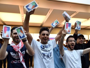 First customers display their iPhone X sets at an Apple showroom in Sydney Friday.