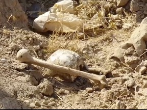 In this Saturday, Nov. 11, 2017 frame grab from video, bones lie on the ground in an area recently retaken from the Islamic State group, at an abandoned base near the northern town of Hawija, Iraq.