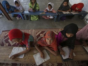 Burmese refugee children who fled from Myanmar with their families study at a makeshift religious school in the suburbs of Karachi, Pakistan, Thursday, Nov. 2, 2017. (AP Photo/Fareed Khan)