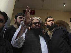 Hafiz Saeed, head of the Pakistani religious party, Jamaat-ud-Dawa, waves to his supporters at a mosque in Lahore, Pakistan, Friday, Nov. 24, 2017. Pakistani authorities acting on a court order released a U.S.-wanted militant Friday who allegedly founded a banned group linked to the 2008 Mumbai, India attack that killed 168 people, his spokesman and officials said. (AP Photo/K.M. Chaudary)