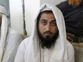 In this picture taken on May 4, 2017, a handcuffed Pakistani cleric who accused of the rape of a student, waits for his turn outside a court in Kehror Pakka, Pakistan. Sexual abuse in madrassas is widely known to happen in Pakistan, but culture, shame and fear all combine to make the reporting of these incidents by victims rare. (AP Photo/K.M. Chaudary)