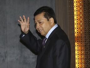 In this Tuesday, July 18, 2017 photo, Indonesian House Speaker Setya Novanto waves at reporters after a press conference in Jakarta, Indonesia.  The top Indonesian politician embroiled in a scandal involving an epic theft of public money has been hospitalized after a car crash that is being widely mocked online as another tactic to avoid arrest.  (AP Photo/Tatan Syuflana)