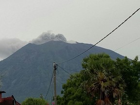 Mount Agung emits volcanic smoke and ash from its crater as seen from Tulamben, Bali, Indonesia, Tuesday, Nov. 21, 2017. The volcano on the Indonesian tourist island has spewed ash and smoke, but authorities say its alert level remains unchanged. (AP Photo/Wayan Wijaya)