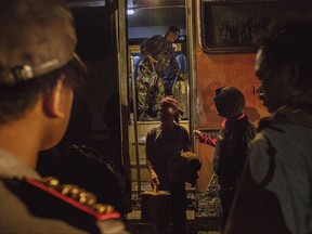 A man who was evacuated after a security operation against separatists in his village, steps out of a bus upon arrival at a temporary shelter in Timika, Papua province, Indonesia, Friday, Nov. 27, 2017. Indonesian police said they helped evacuate some hundreds of people Friday from villages in the easternmost province after security forces apparently gained the upper hand in a standoff with the separatists.(AP Photo/Albertus Vembrianto)